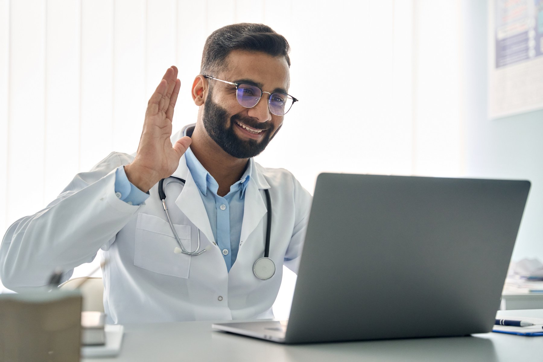 Doctor Waving on Laptop 